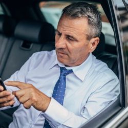 Man inside his car using his phone